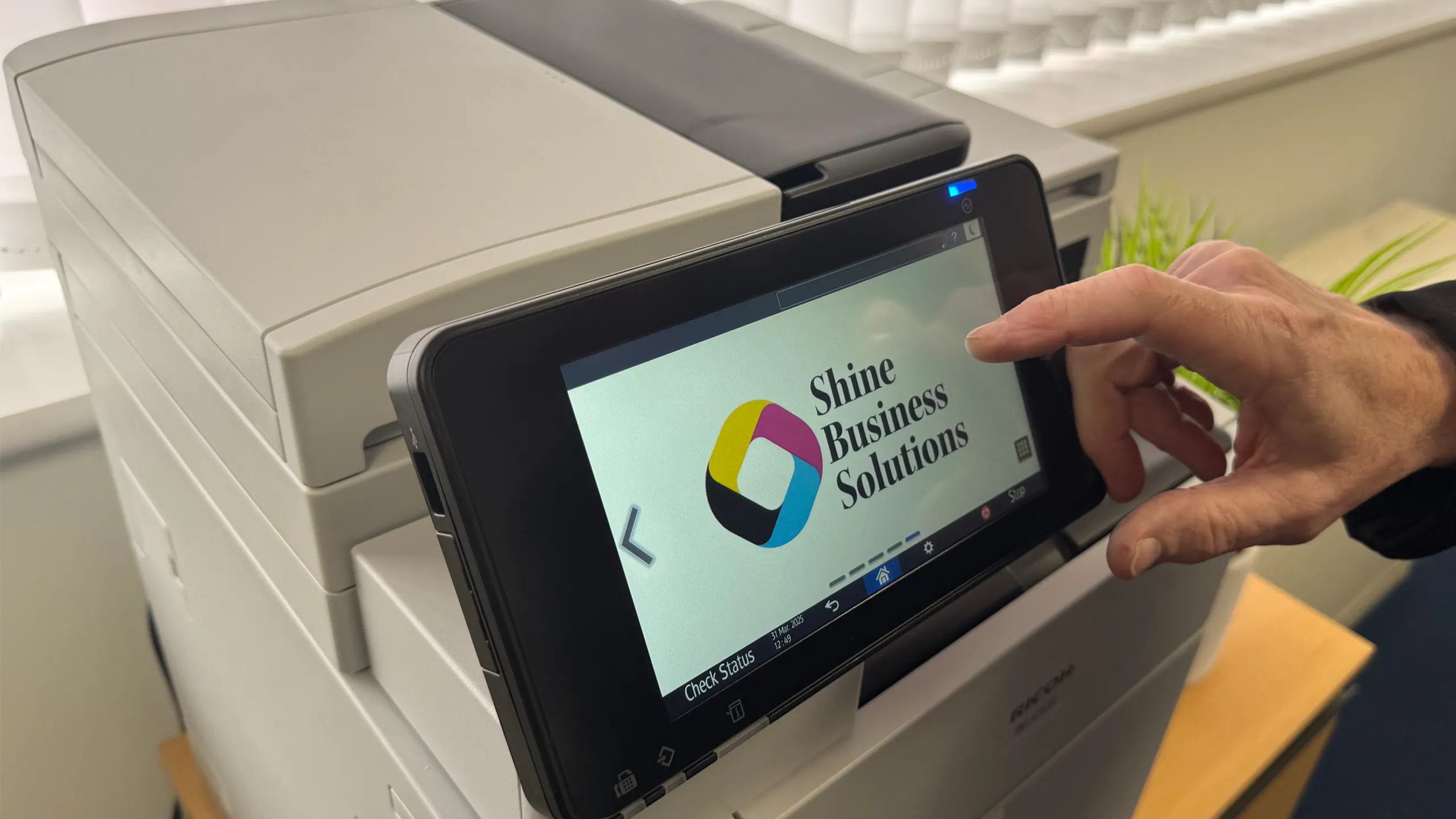 Multifunction printer screen with Shine Business Solutions branding for managed print services.